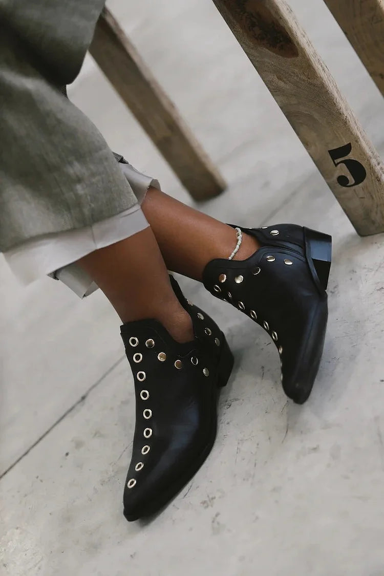 Schwarze Stiefeletten mit spitzem Zehenbereich und dekorativen Metallösen