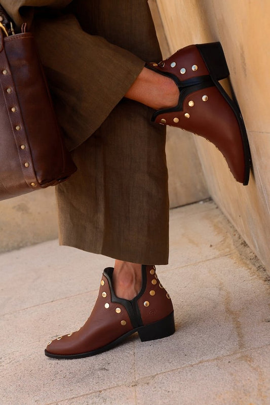 Dunkelbraune Stiefeletten mit spitzem Zehenbereich und metallischem Ösendekor