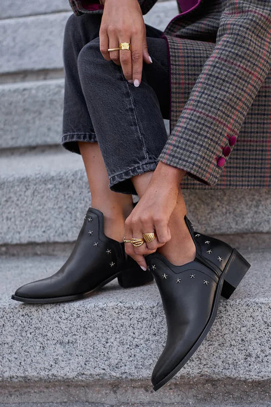 Schwarze Stiefeletten mit metallischem Stern-Design und spitzem Zehenbereich