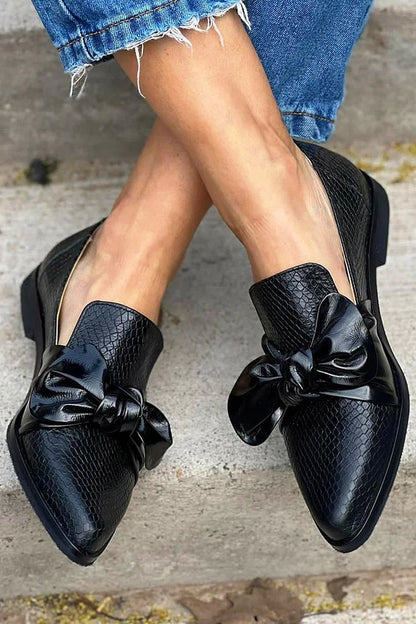 Schwarze Slip-On Slipper mit Schlangenleder-Optik, Schleife und spitzem Zehenbereich